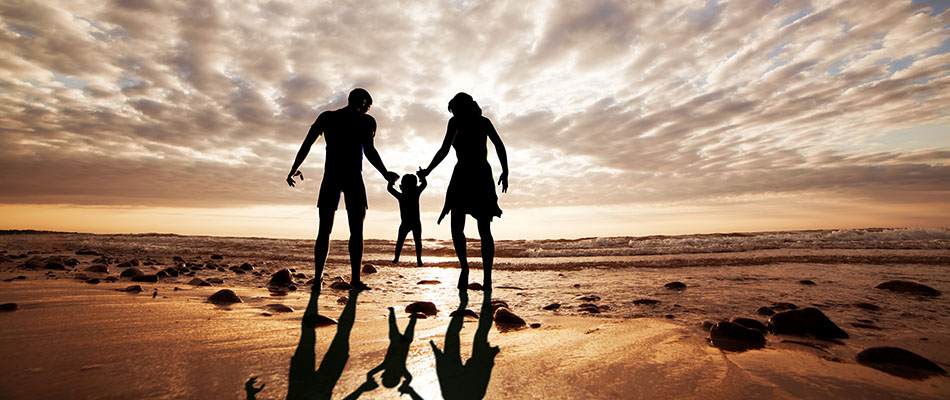 Happy family together hand in hand on the beach at sunset. Summe